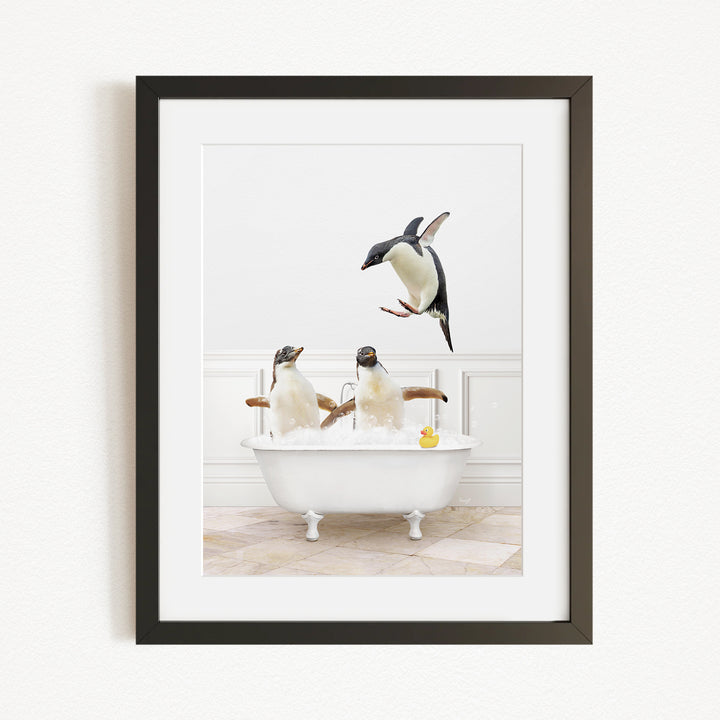 A framed image depicting three penguins sitting in a bathtub, with one penguin flying towards the tub.