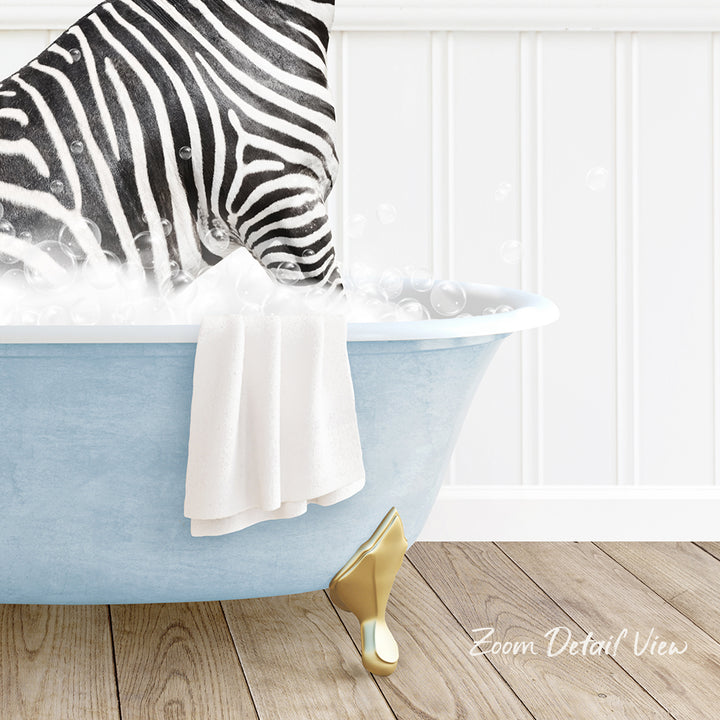 A zebra standing in a blue bathtub filled with bubbles, with a white towel and gold shoe visible in the foreground.