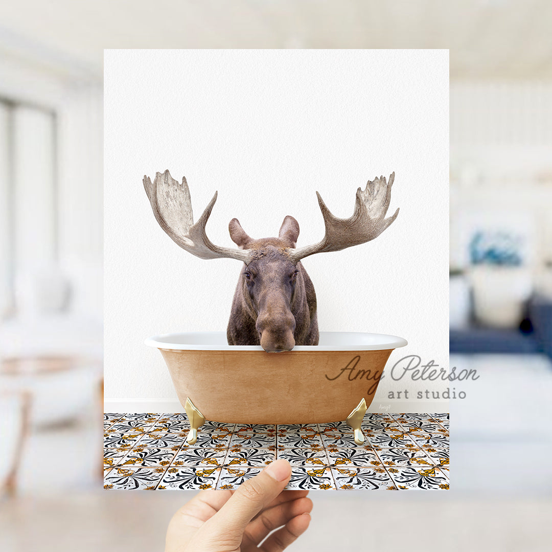 a hand holding a card with a moose head in a bathtub