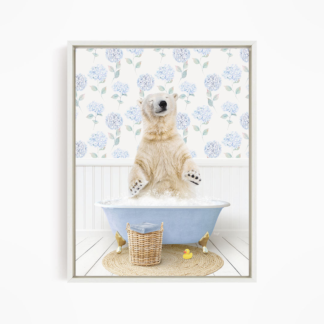 A polar bear is sitting in a blue bathtub filled with water, surrounded by a wicker basket and a yellow rubber duck.