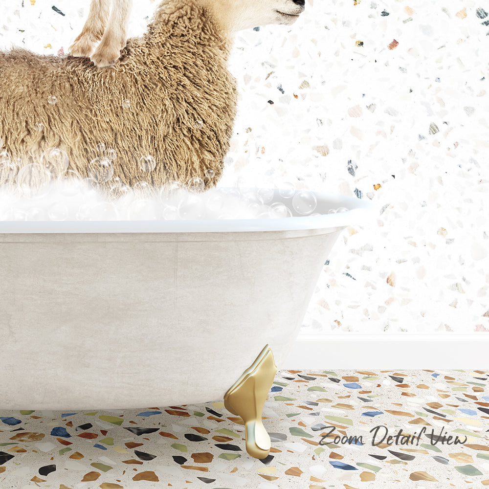 A fluffy brown sheep is sitting in a white bathtub filled with bubbles, with a mosaic floor in the background.