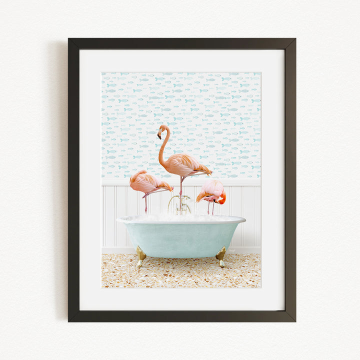 A framed image depicting three flamingos standing in a bathtub filled with water, with a patterned wall behind them.
