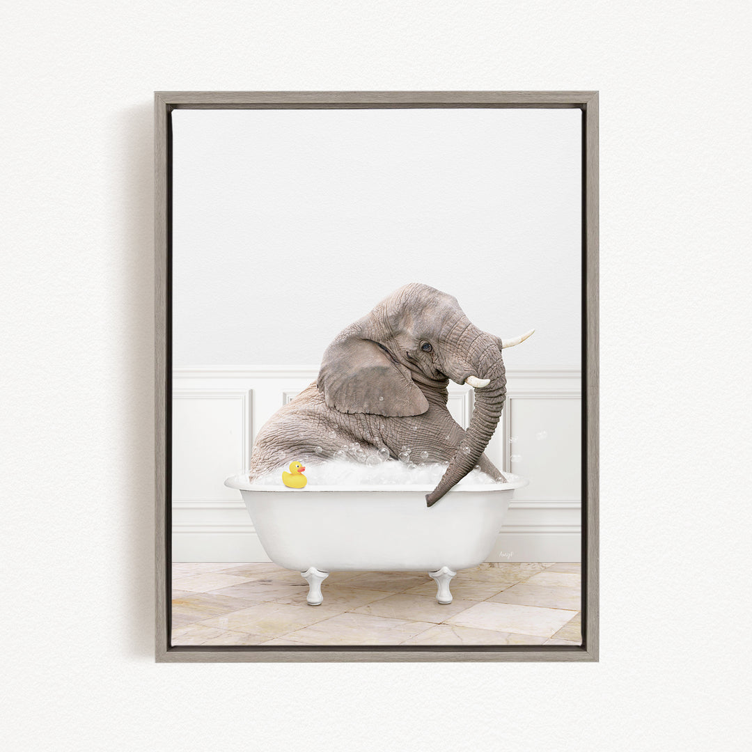 A gray elephant is sitting in a white bathtub filled with water, with a yellow rubber duck floating nearby.