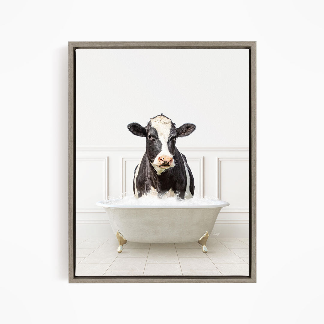 A black and white cow is standing in a white bathtub filled with water, creating a humorous and whimsical scene.