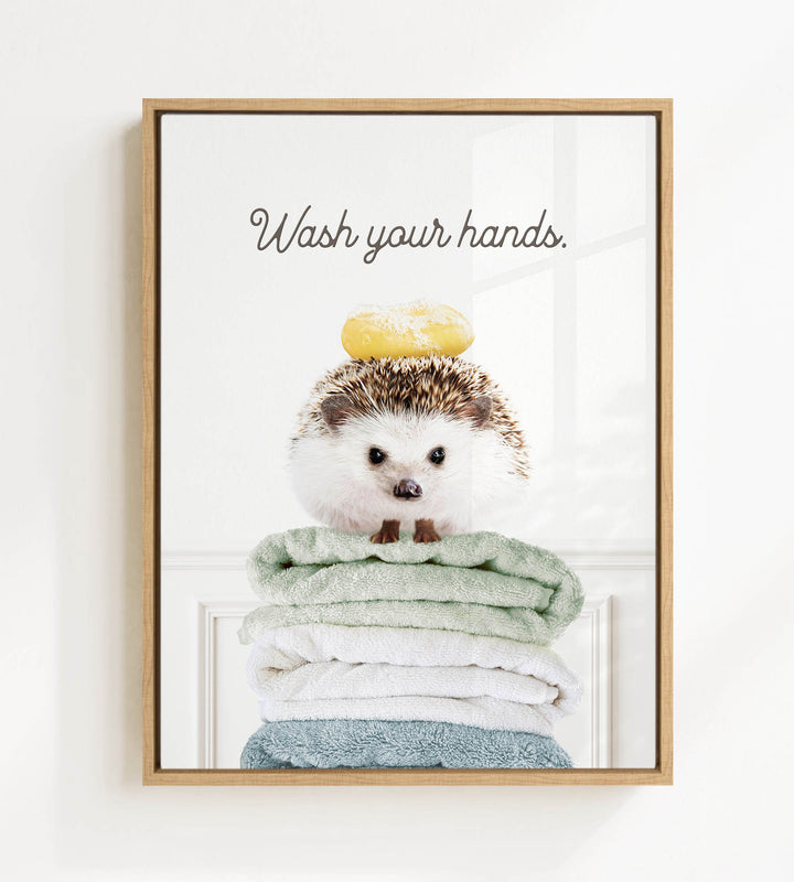 A cute hedgehog sitting on a stack of folded towels, with the text "Wash your hands" written above it.