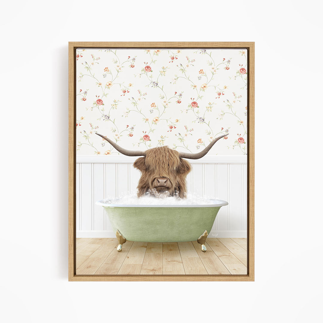 A brown cow with long horns is sitting in a green bathtub filled with water, surrounded by a floral wallpaper.