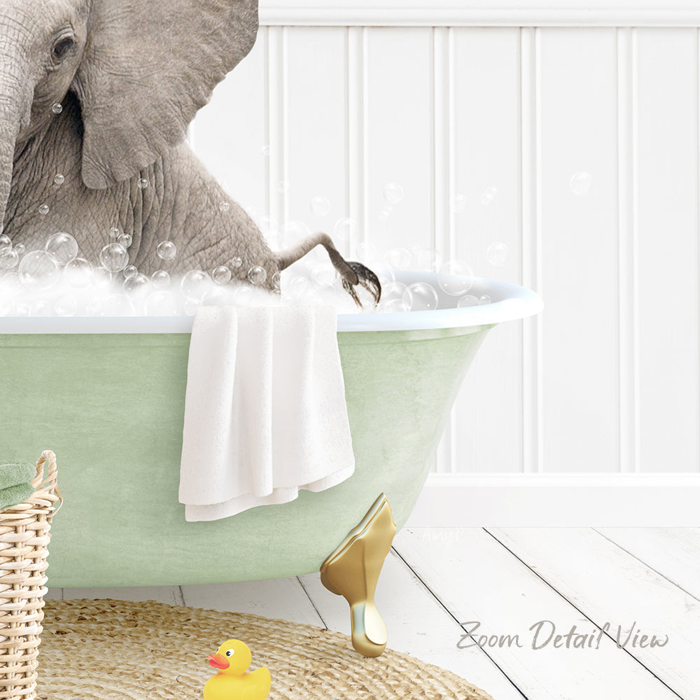A gray elephant is sitting in a green bathtub filled with bubbles, surrounded by a yellow rubber duck and a white towel.