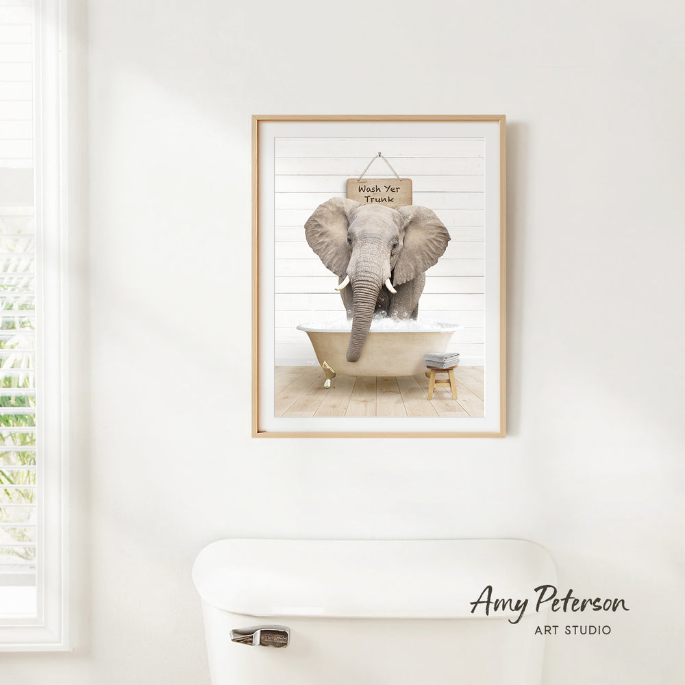 A framed image of an elephant standing in a bathtub, with a sign above it that says "Wash Your Thighs".