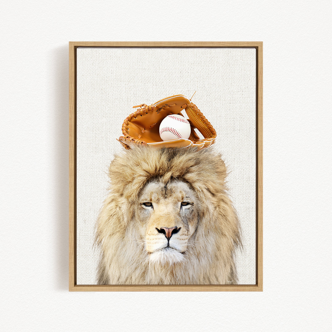 A framed image of a lion wearing a baseball glove on its head, with a baseball resting on top of the glove.