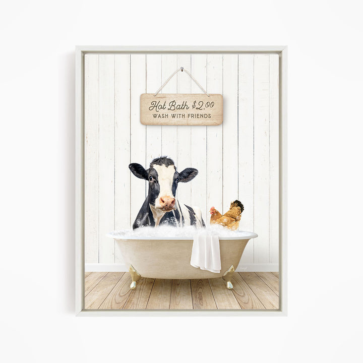 A black and white cow is sitting in a bathtub filled with water, with a sign above the tub that reads "Hot Bath $2.00 WASH WITH FRIENDS".