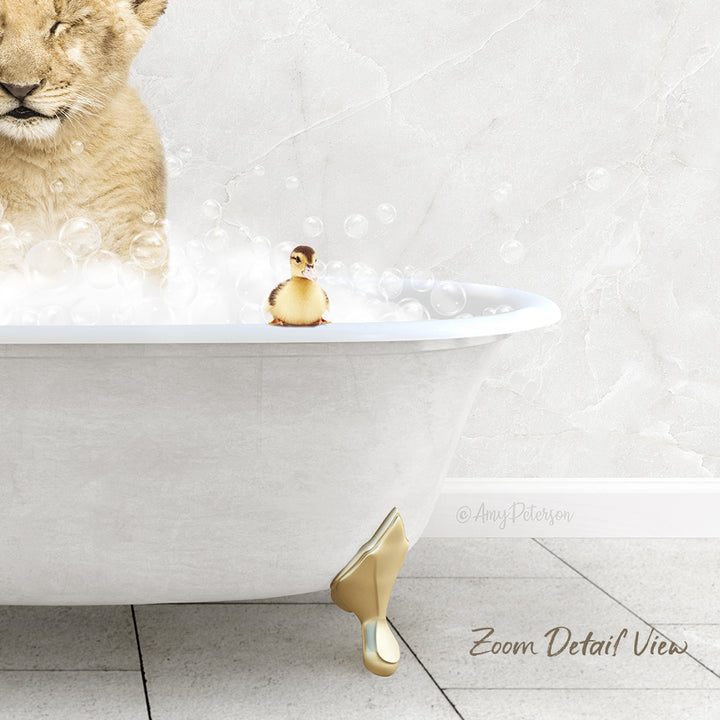 A lion cub is taking a bath in a white bathtub, with a small yellow duck sitting on the edge of the tub.
