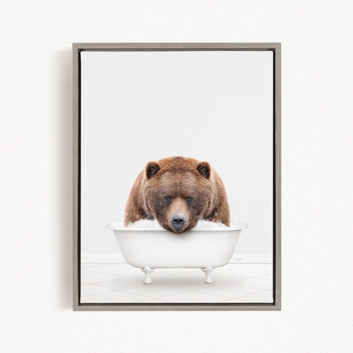 A brown bear sitting in a white bathtub filled with bubbles, appearing to enjoy the bath.