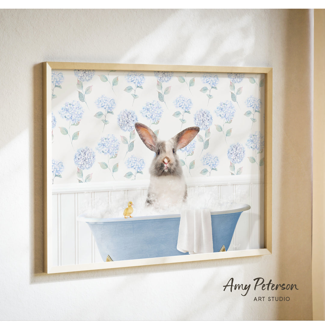 A framed image of a rabbit sitting in a bathtub filled with water, surrounded by blue hydrangea flowers.