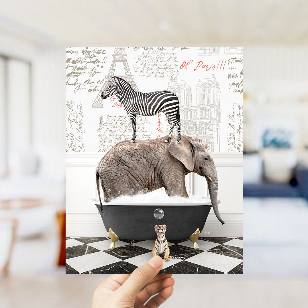 A hand holds up a collage of images depicting a zebra standing on an elephant's back, with a small tiger figurine in a bathtub, all set against a backdrop of a Paris-themed wall.