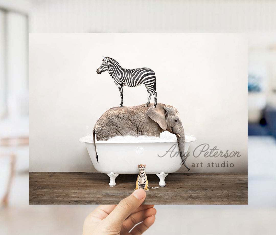 a person holding up a picture of a zebra and an elephant in a bathtub