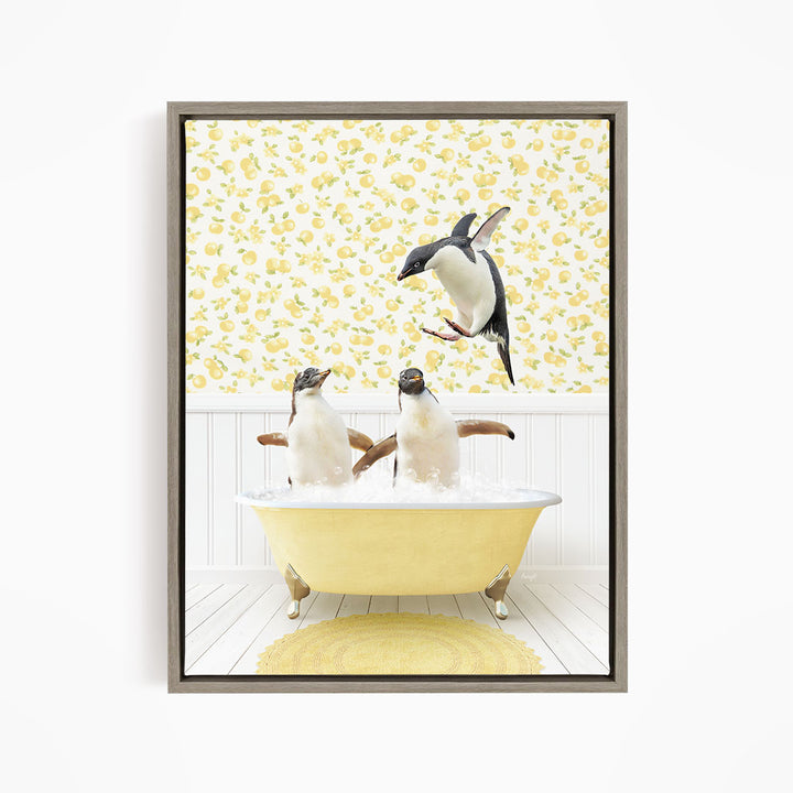 A framed image depicting two penguins sitting in a yellow bathtub, with one penguin jumping out of the tub.