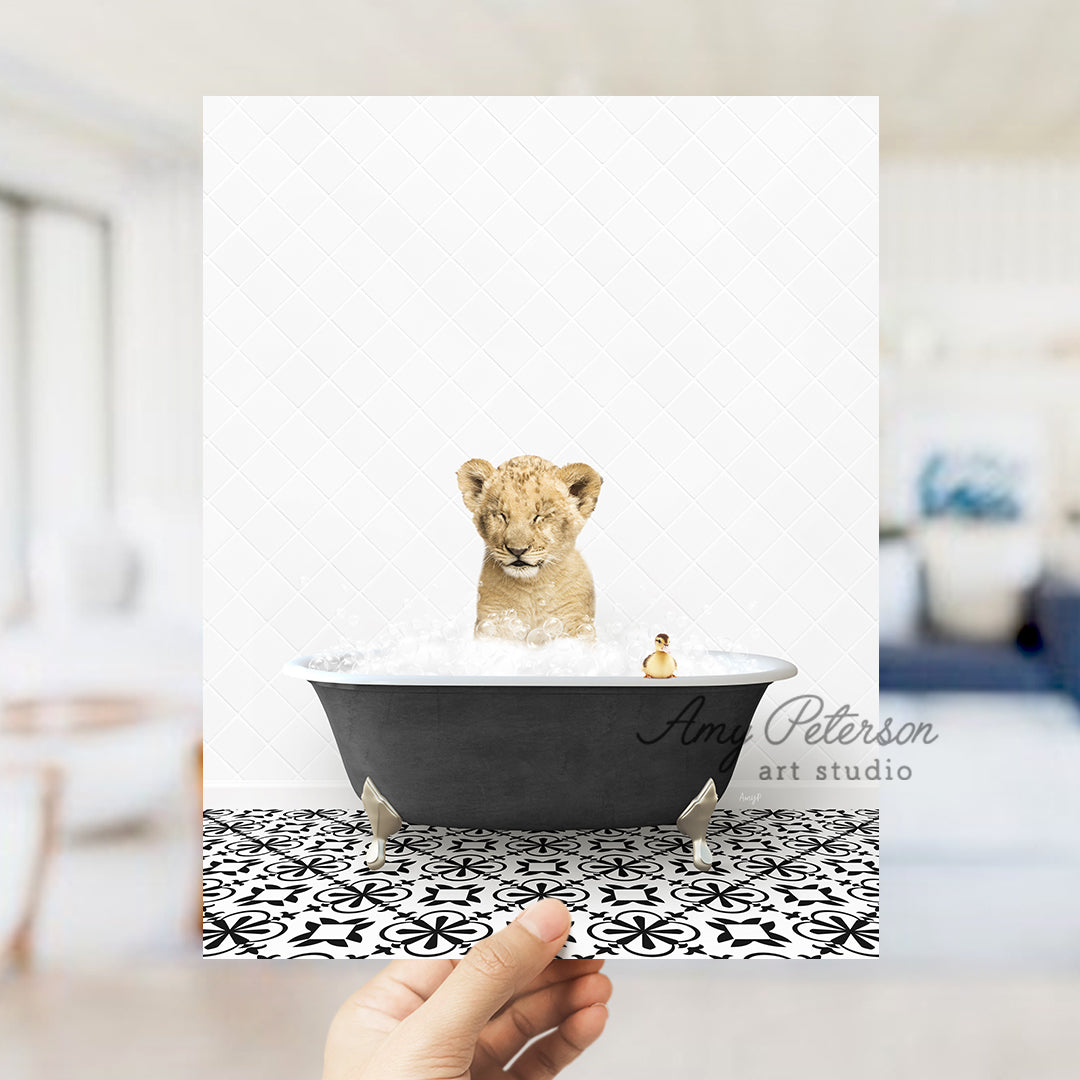 a hand holding a card with a picture of a baby lion in a bathtub