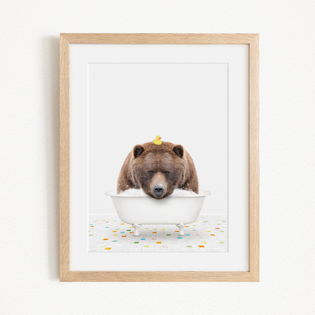 A brown bear is sitting in a white bathtub, with a rubber duck perched on its head.