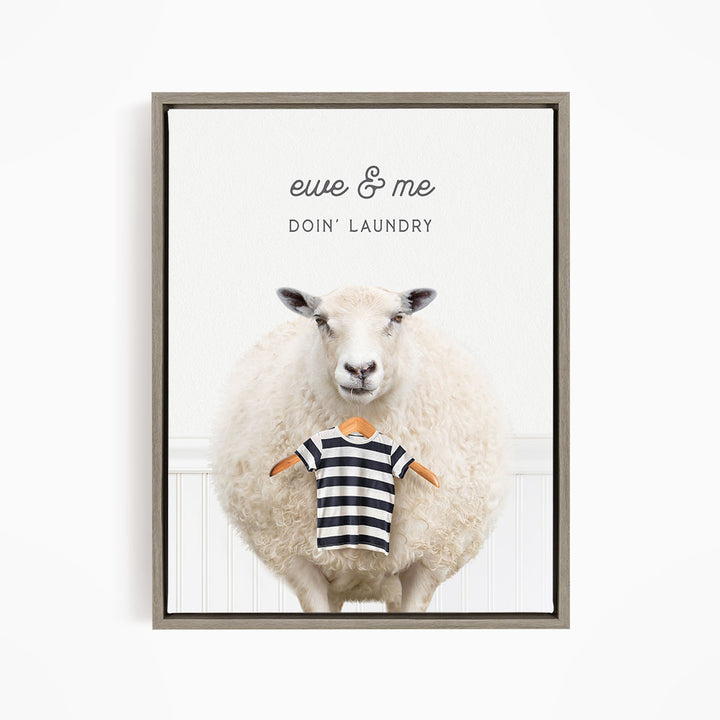 A framed image depicting a sheep wearing a striped shirt, with the text "ewe & me DOIN' Laundry" written above it.