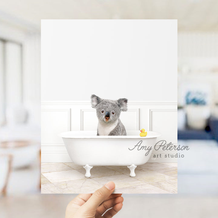 a hand holding a card with a picture of a koala in a bathtub