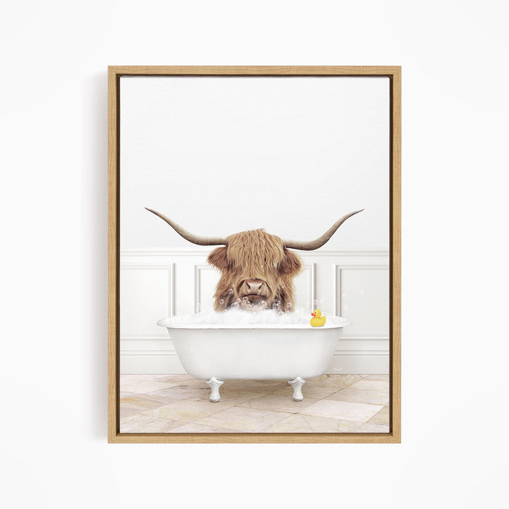 A long-haired cow with large horns is sitting in a white bathtub, surrounded by a yellow rubber duck.