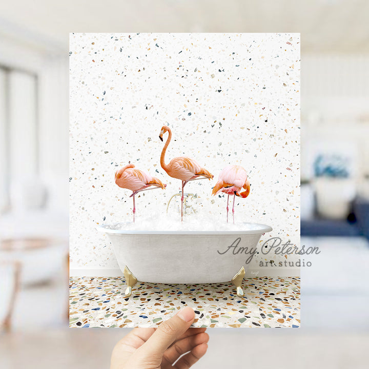 a person holding up a card with flamingos in a bathtub