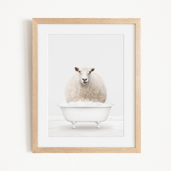 A fluffy white sheep sits in a white bathtub, surrounded by a simple white background.