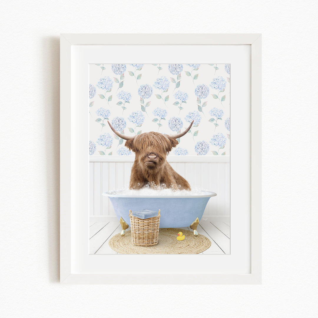 A brown cow with long horns is sitting in a blue bathtub filled with water, surrounded by a white floral pattern on the wall behind it.