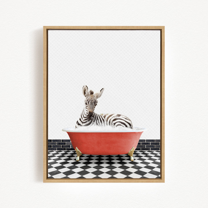 A zebra is sitting in a red bathtub on a black and white checkered floor.