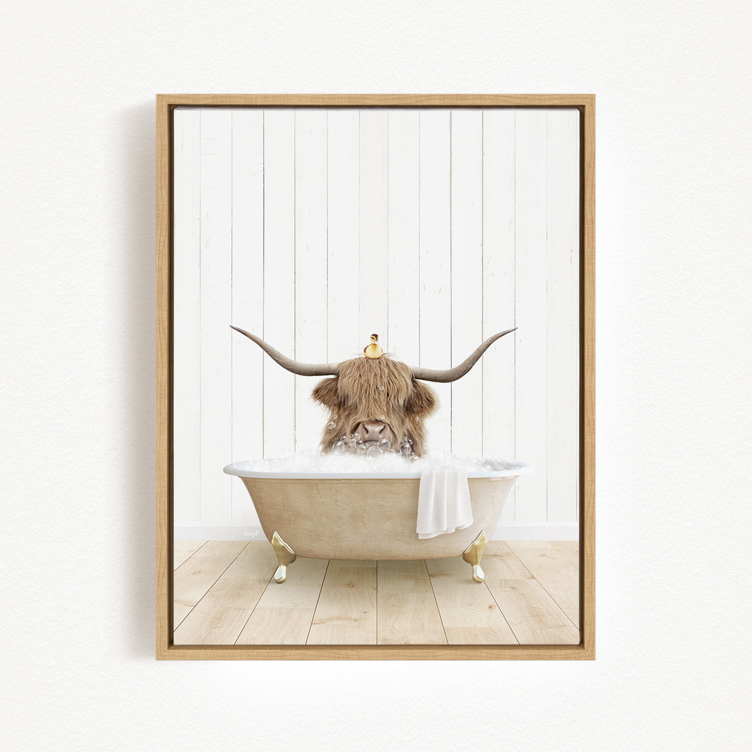 A brown cow with large horns is sitting in a bathtub filled with water, with a yellow bird perched on its head.
