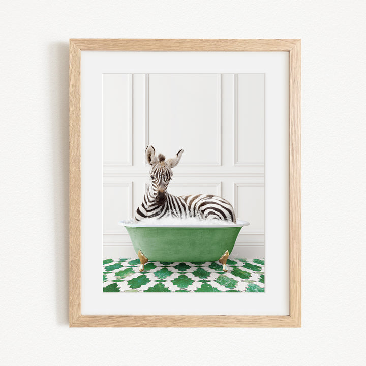 A zebra is sitting in a green bathtub, surrounded by a patterned green and white rug.