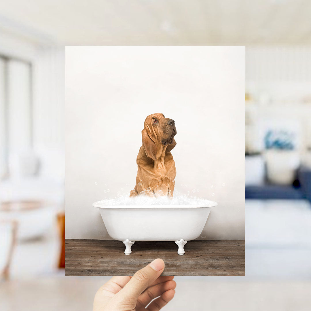 A brown dog sitting in a white bathtub filled with water, with bubbles around it, and a blurred background suggesting a bathroom setting.