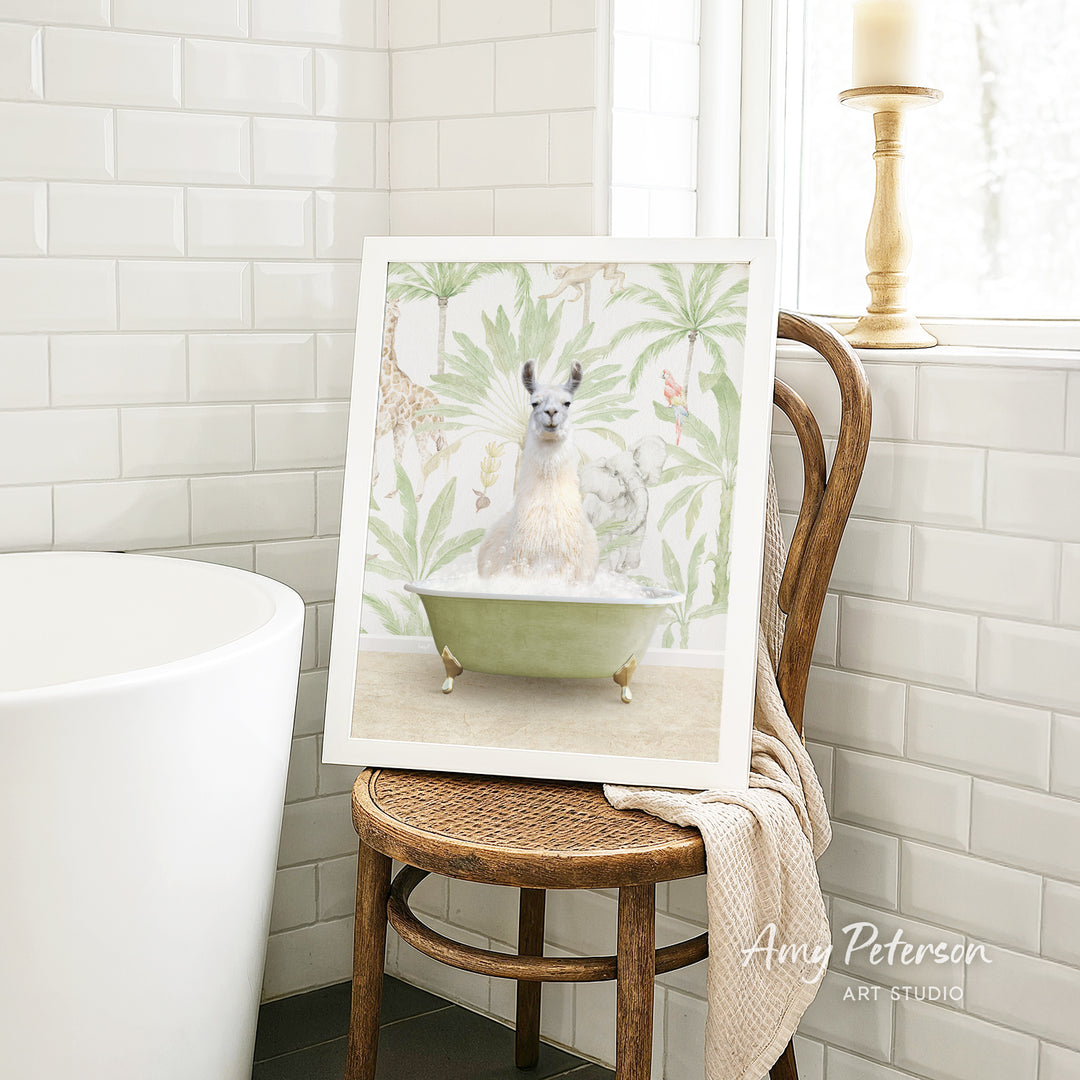A framed image of a white llama sitting in a green bathtub, surrounded by tropical foliage, is displayed on a wooden chair in a bathroom setting.