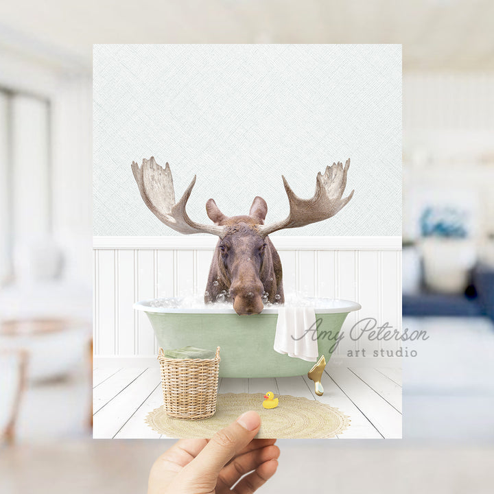 a person holding up a picture of a moose in a bathtub