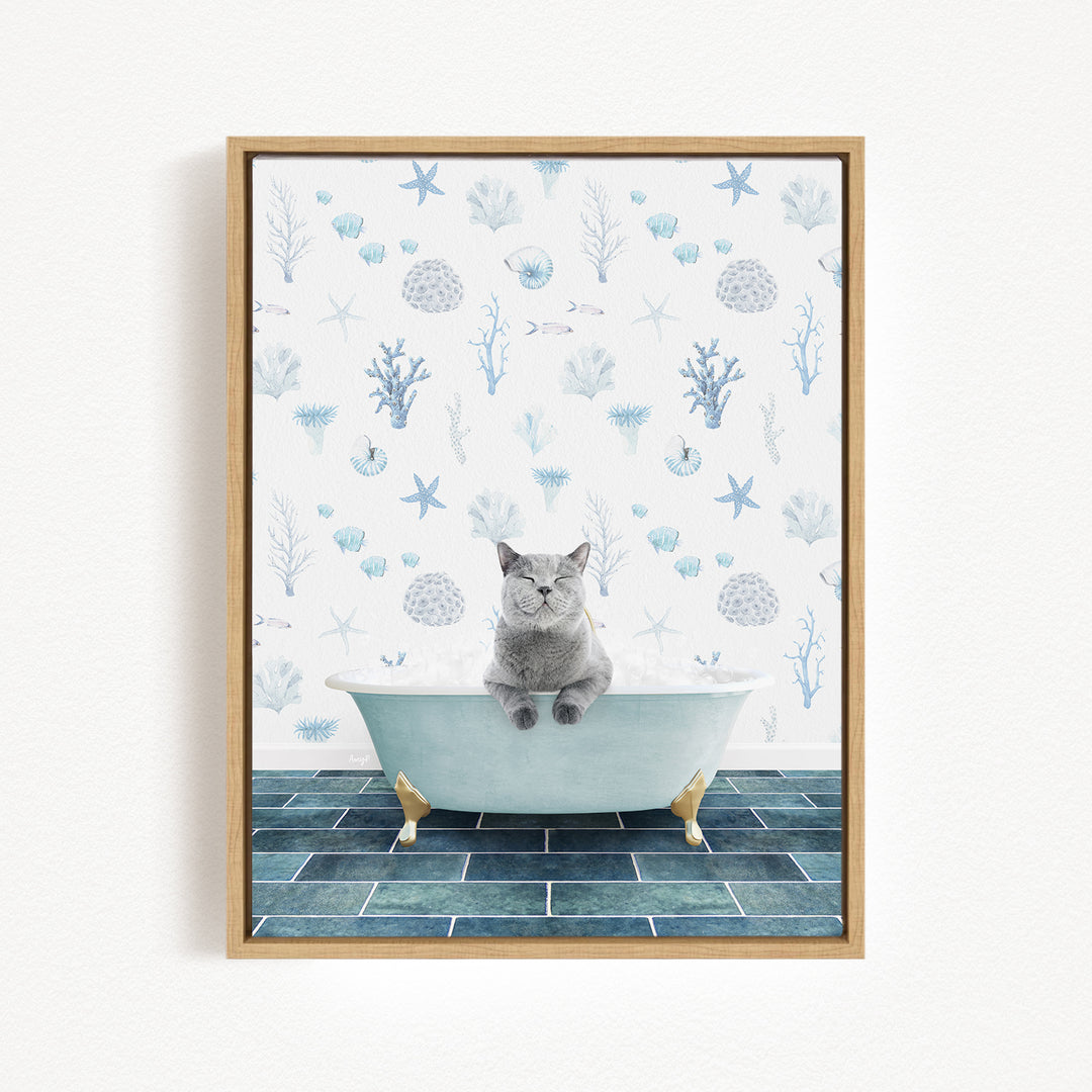 A gray cat sitting in a white bathtub, surrounded by a blue and white ocean-themed wallpaper.