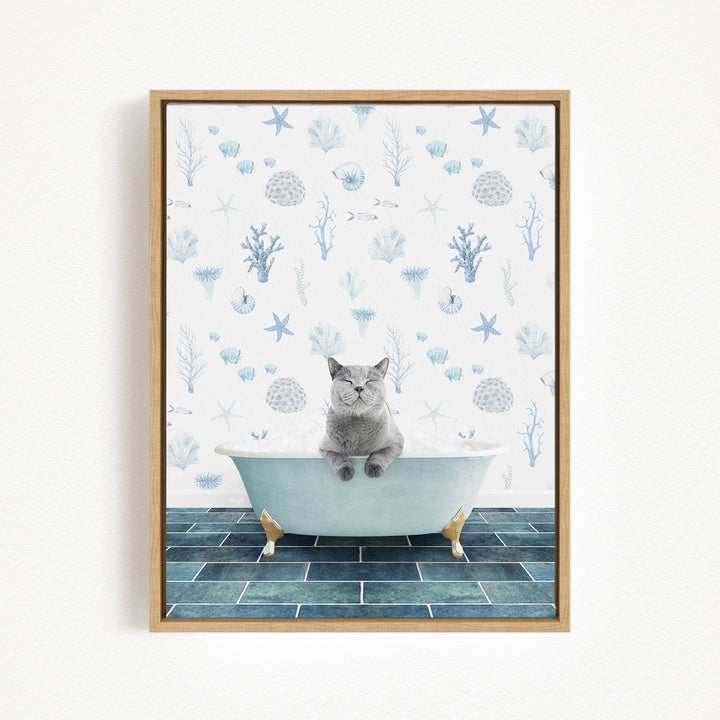 A gray cat sitting in a white bathtub, surrounded by a blue and white ocean-themed wallpaper.