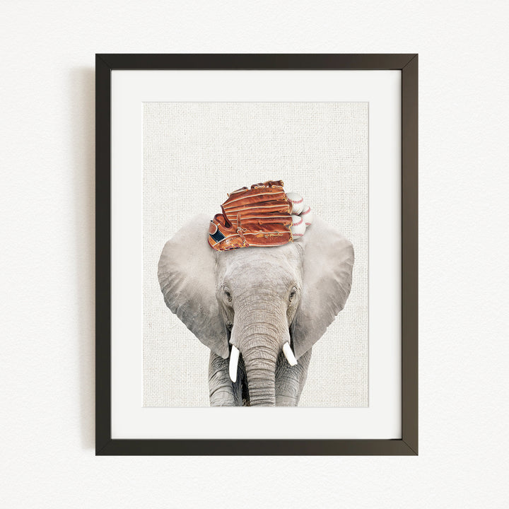 A framed photograph of an elephant wearing a baseball cap.