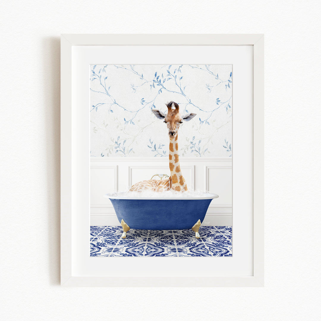 A giraffe is sitting in a blue bathtub, surrounded by a patterned tile floor and a white wall with blue floral wallpaper.