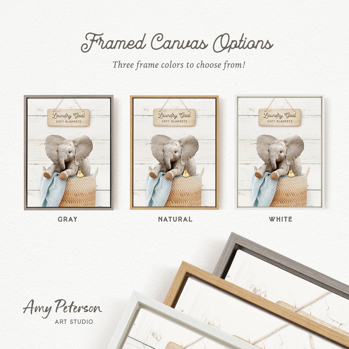 The image is a framed canvas option featuring three different color options for a laundry-themed artwork. The options include gray, natural, and white. The artwork depicts a baby elephant in a basket, and the text indicates that the three frame colors to choose from are gray, natural, and white.