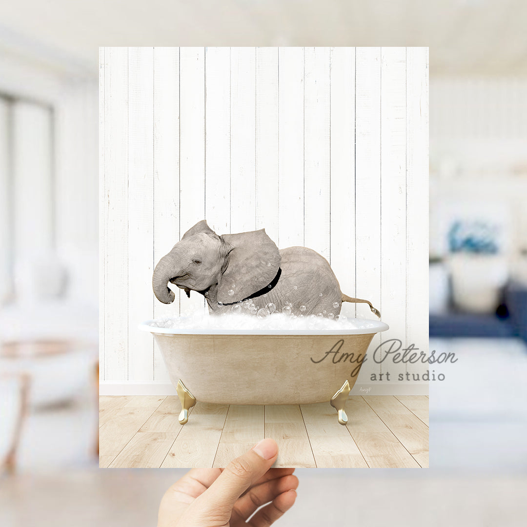 a hand holding a photo of an elephant in a bathtub