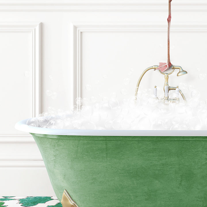 a green bathtub filled with foam and a faucet