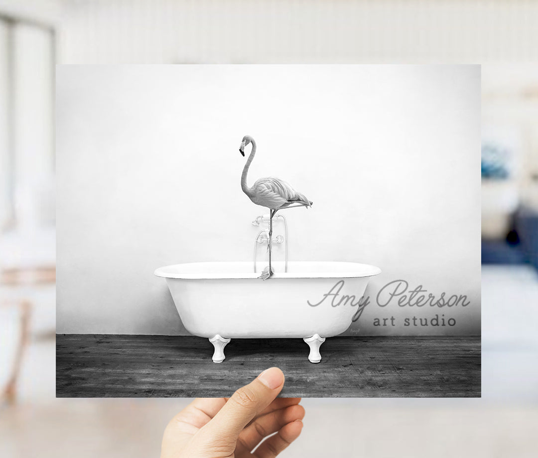 a person holding up a photo of a flamingo in a bathtub