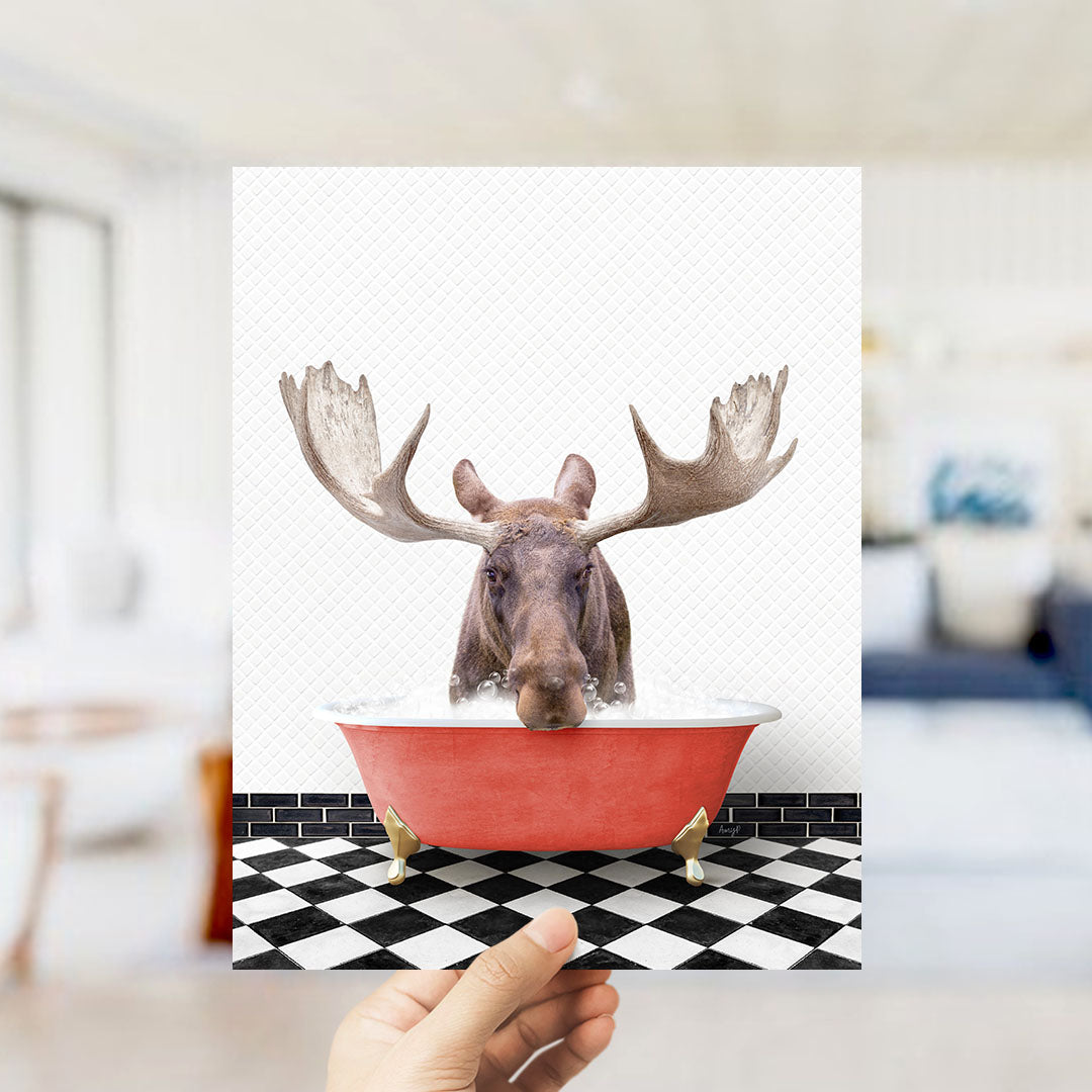 A moose with large antlers is sitting in a red bathtub on a black and white checkered floor.