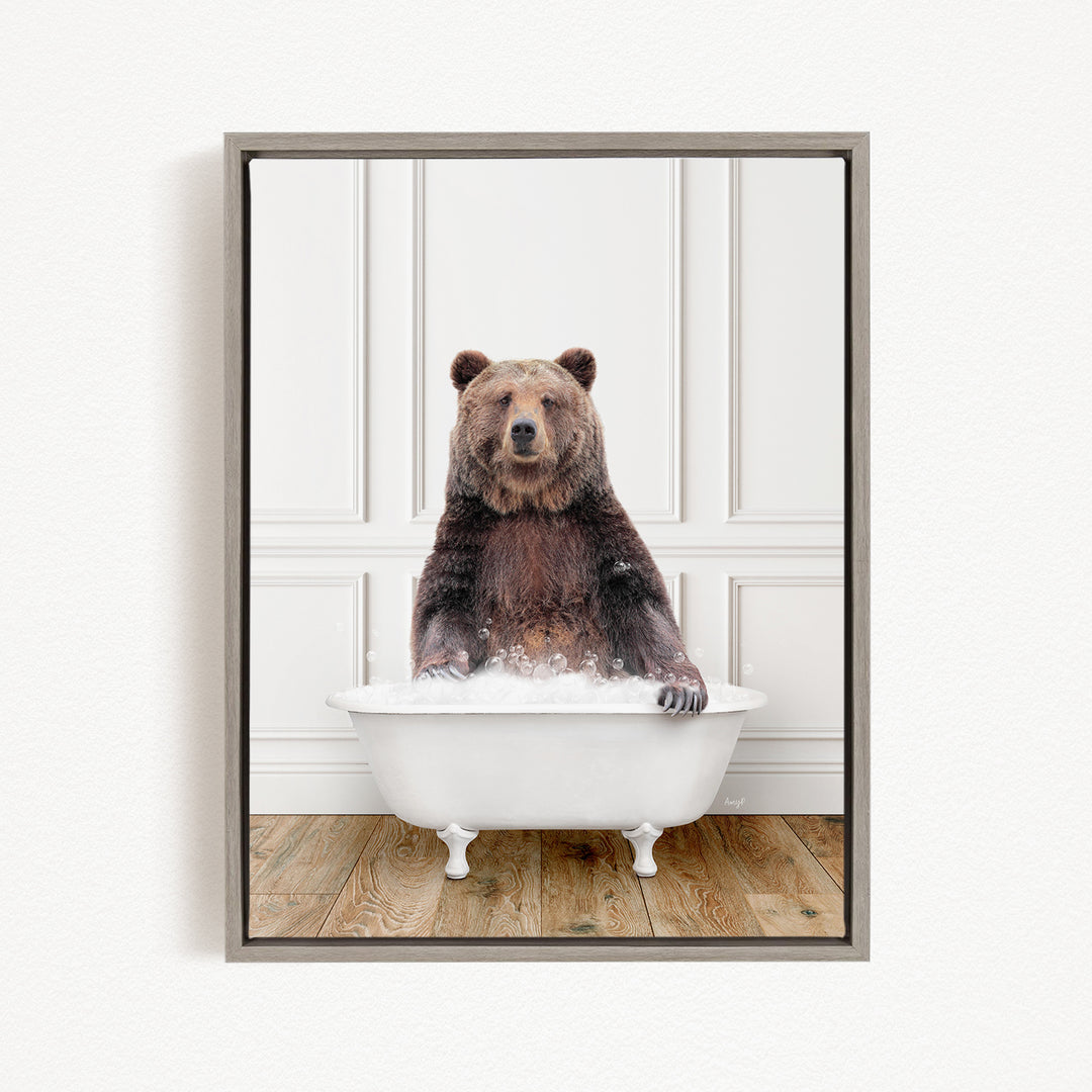 A brown bear sitting in a white bathtub filled with bubbles, looking directly at the camera.