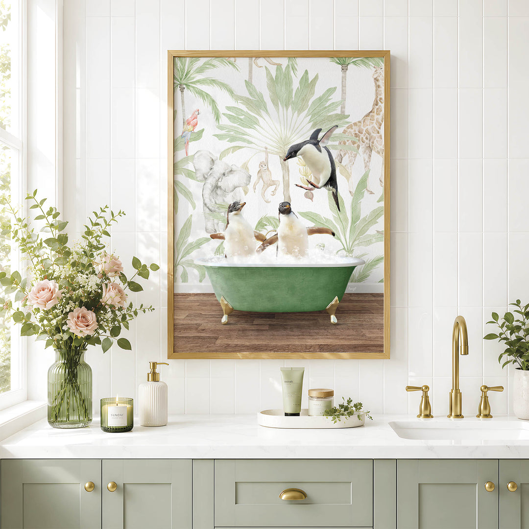 a bathroom scene with a framed painting of penguins in a bathtub, surrounded by tropical foliage. The painting is hung on a white wall above a white countertop with various bathroom accessories, including a vase of flowers, a soap dispenser, and a candle.