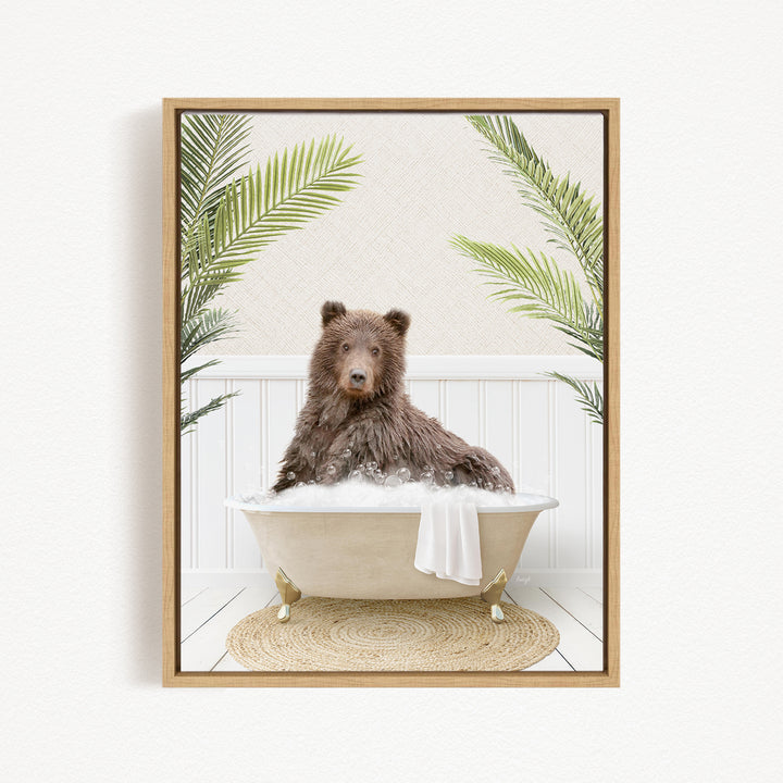 A brown bear sitting in a bathtub filled with water, surrounded by green palm leaves.