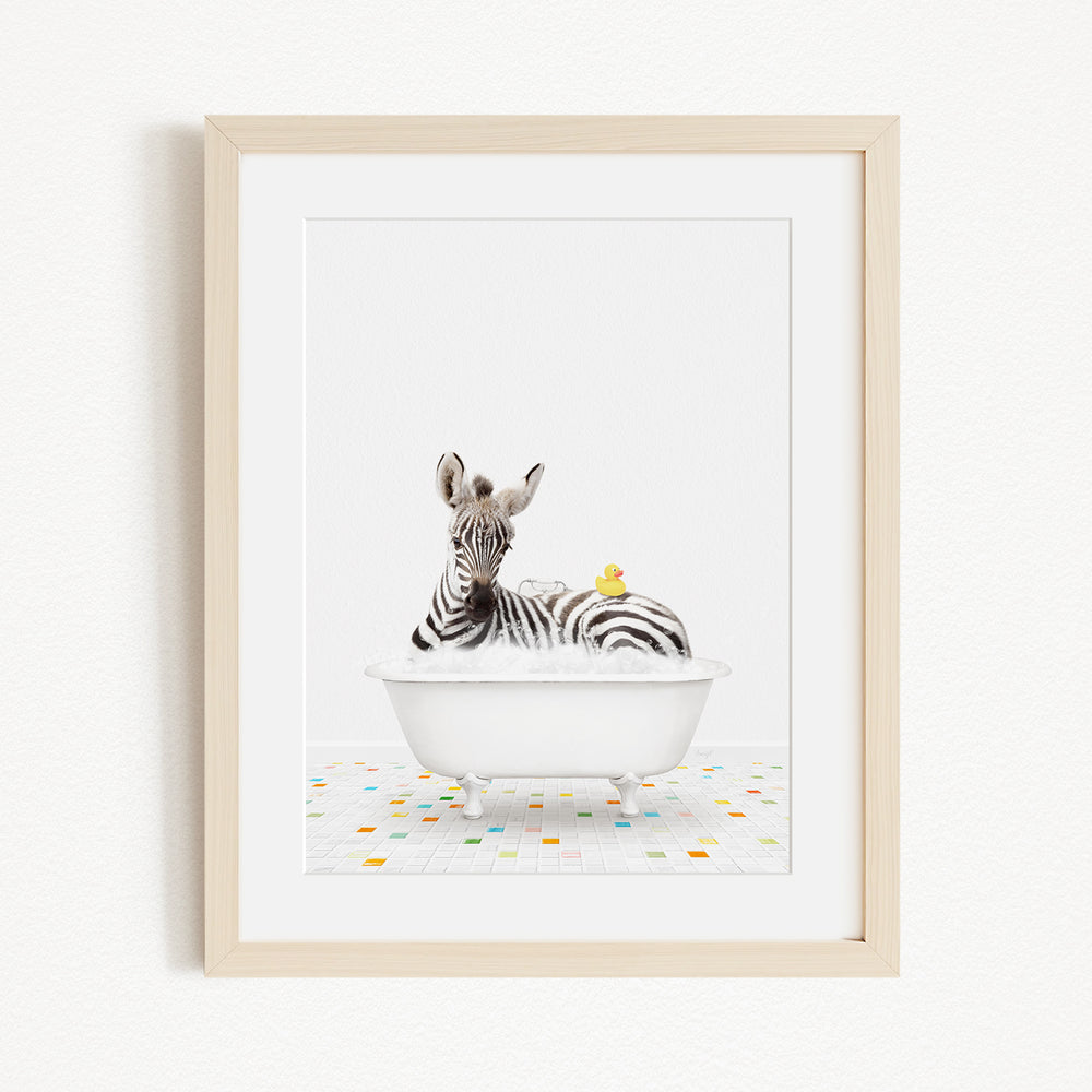 A zebra is sitting in a white bathtub, surrounded by colorful tiles on the floor.