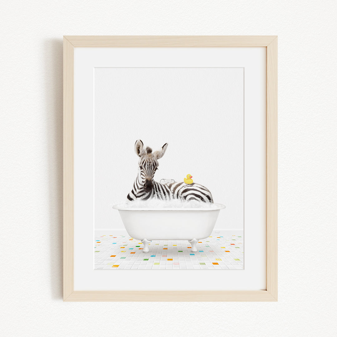 A zebra is sitting in a white bathtub, surrounded by colorful tiles on the floor.