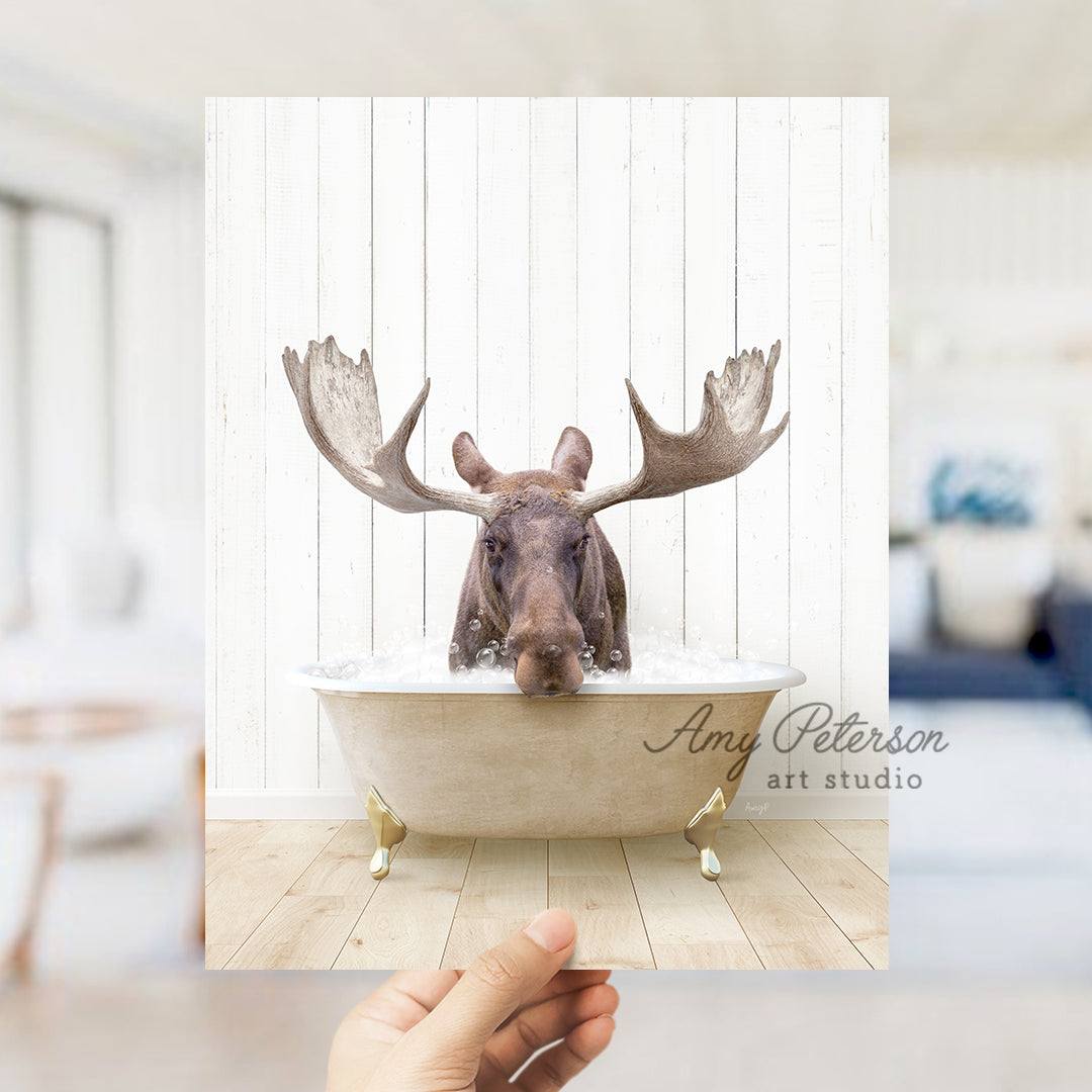 a hand holding up a photo of a moose in a bathtub