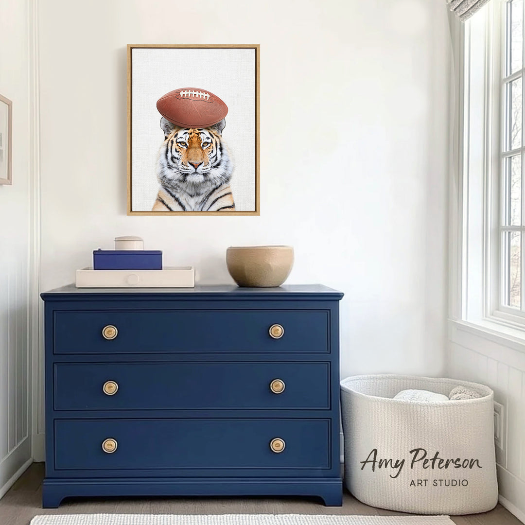 a blue dresser with a framed picture of a tiger wearing a football hat, and a white basket with the text " Amy Peterson ART STUDIO" printed on it.